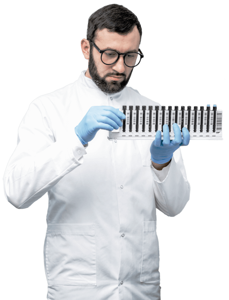 Scientist in lab coat and gloves examining test tubes, with an inset of another researcher using a microscope in a laboratory setting.